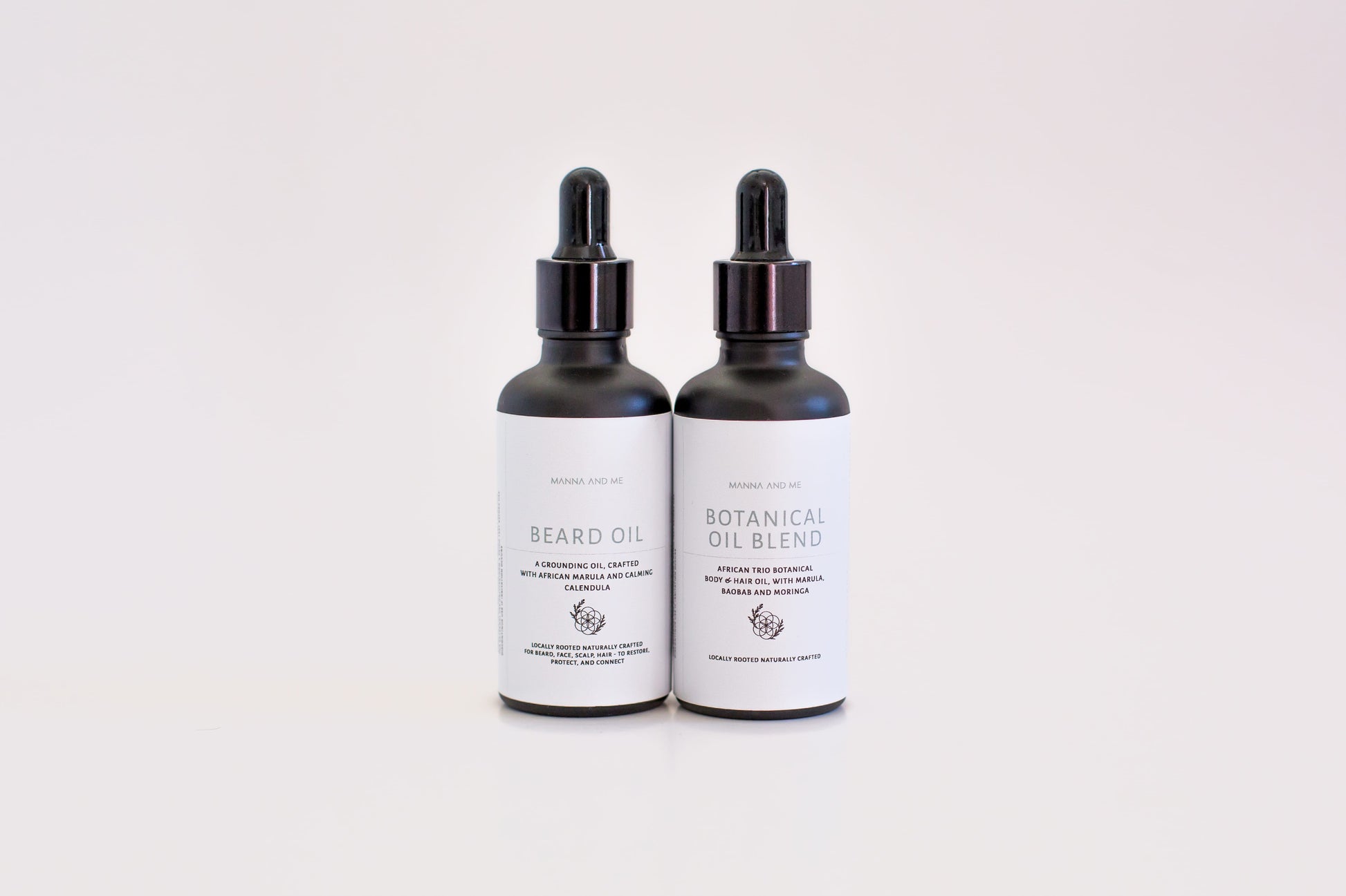 Manna and Me African Trio Body Oil glass bottle, a premium fast-absorbing body oil infused with indigenous South African botanical extracts. Manna and Me natural Beard Oil bottle with dropper, a soothing conditioning treatment crafted to prevent under-beard dryness and skin irritation.